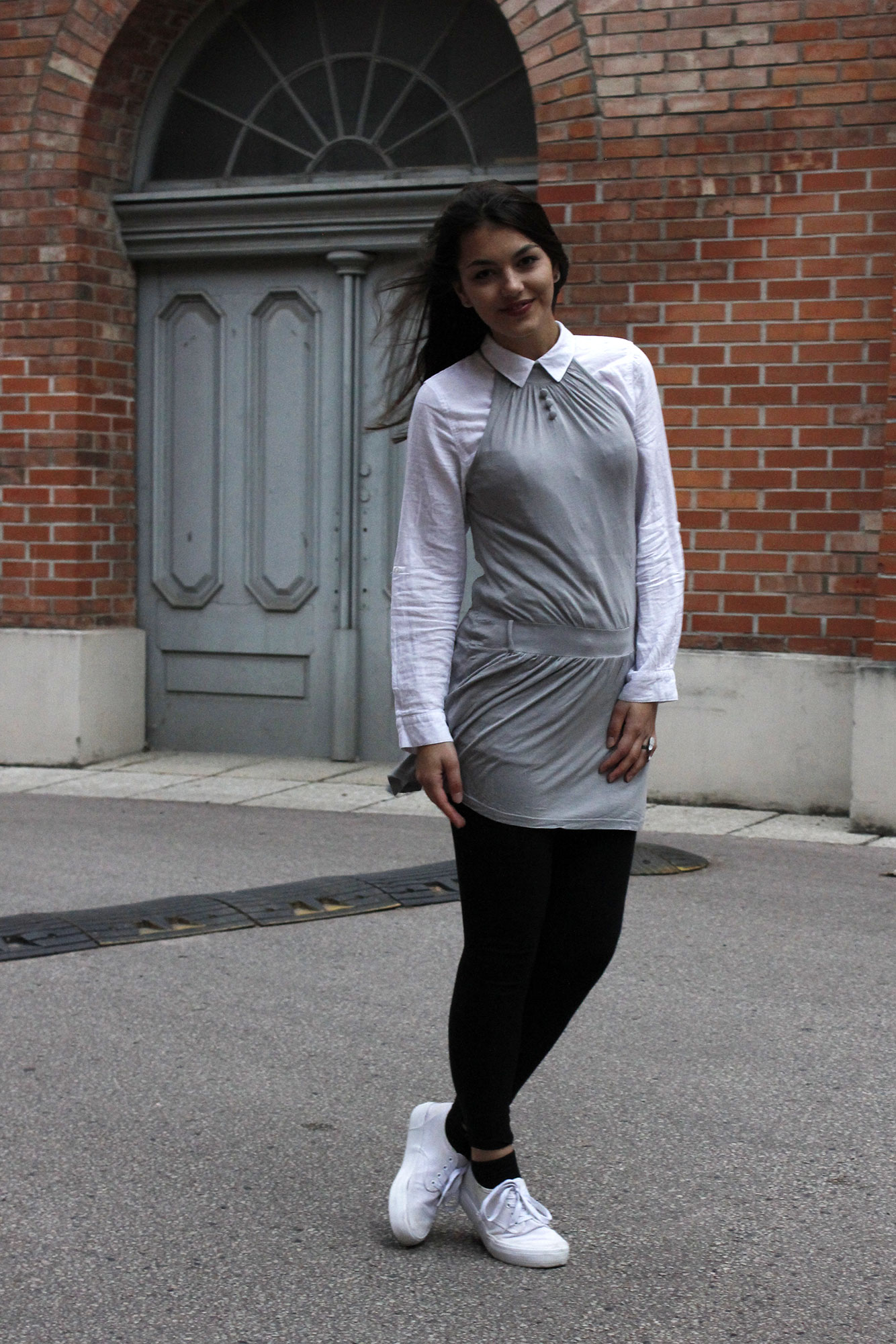 Dorie wearing a grey dress and a white blouse with black legging and white shoes