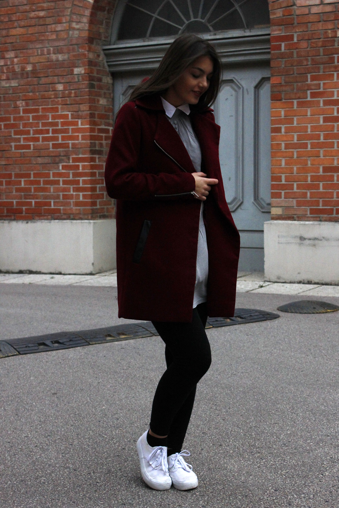 Dorie wearing a red coat and black legging and white shoes