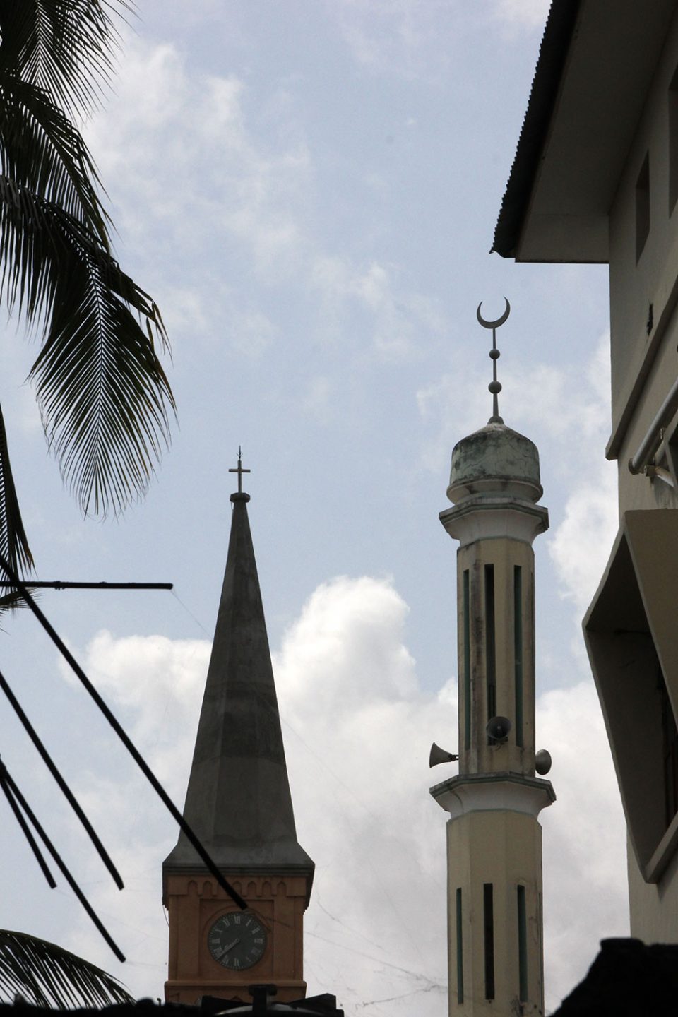 A church's tower next to a mosque's minarett