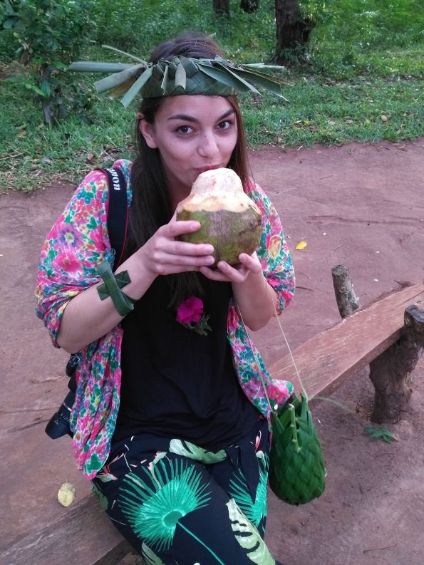 Dorie drinks fresh coconut and wears a hat made from palm leaves
